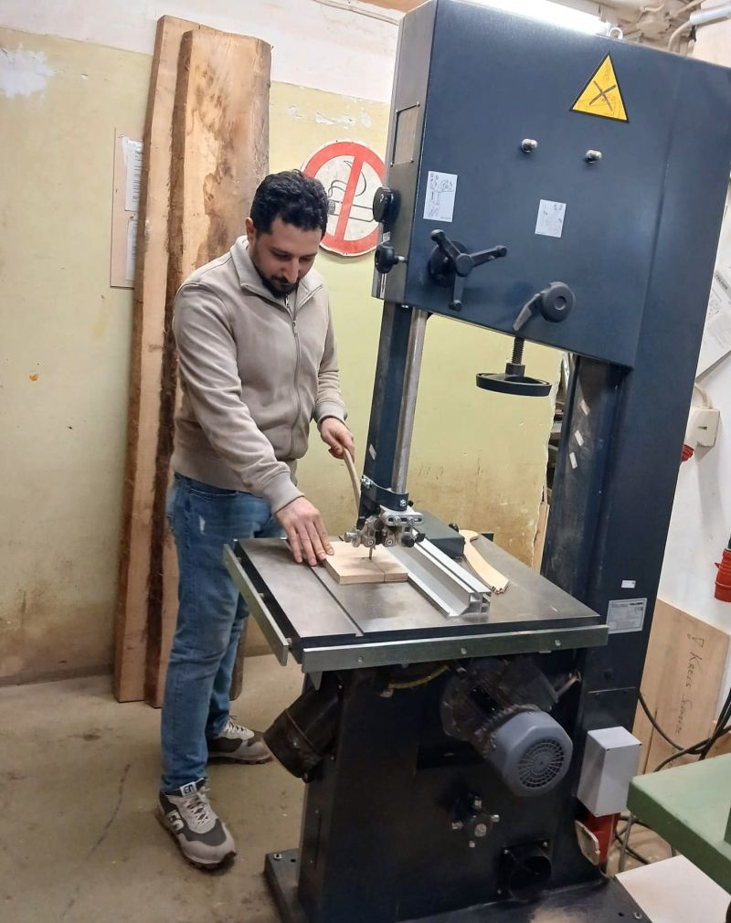 Majed steht an einer großen Sägemaschine.