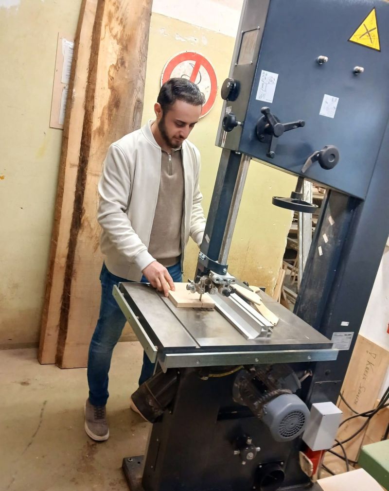 Amjed steht an einer großen Sägemaschine.