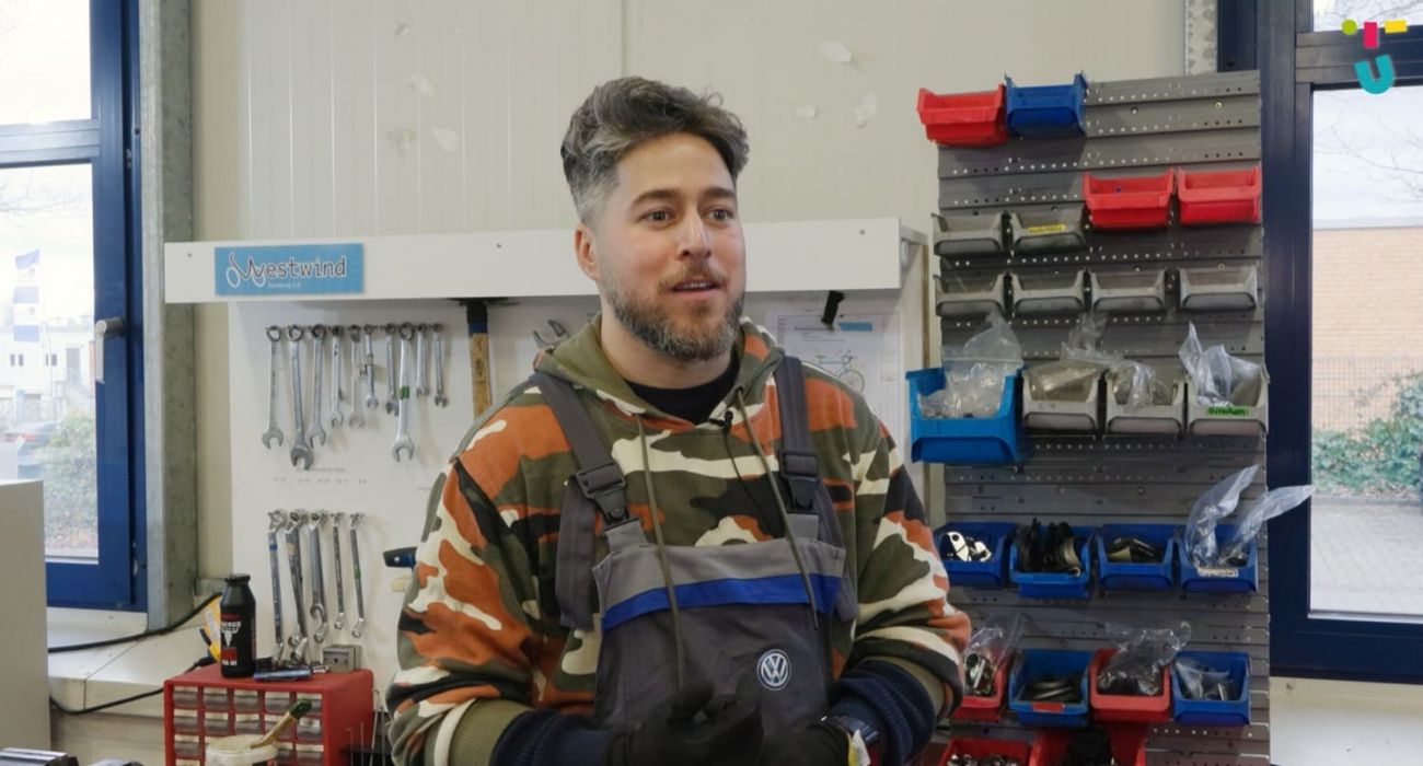 Dariush steht in der Fahrradwerkstatt.