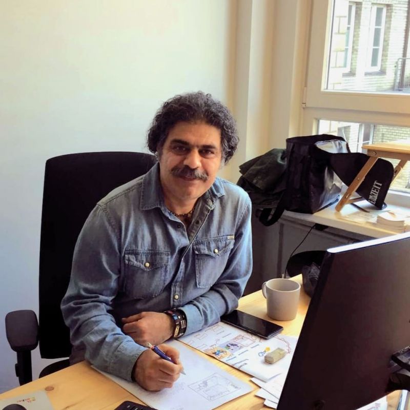 Shiraz sitzt an einem Schreibtisch und zeichnet